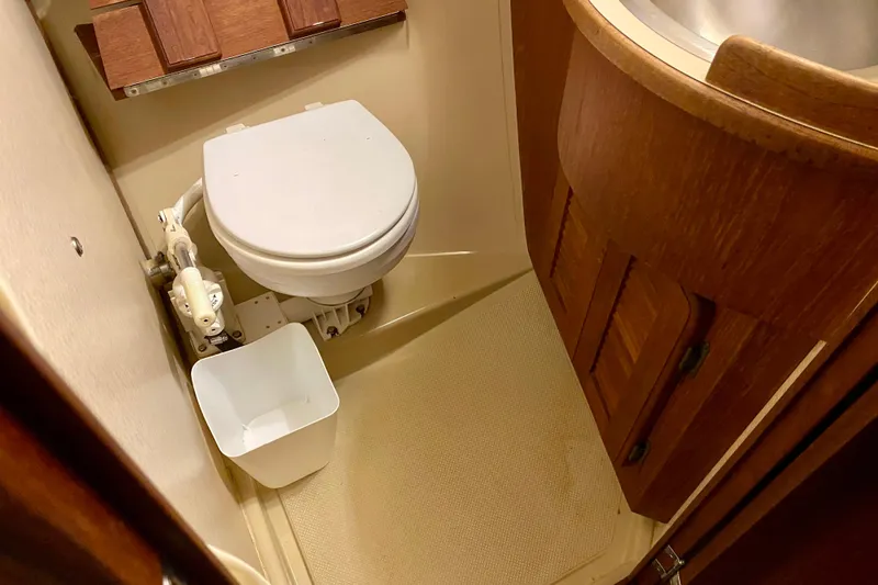 Slide: The Image of Bathroom interior of 1992 Island Packet 29 sailboat, featuring toilet and wooden cabinetry. - 73
