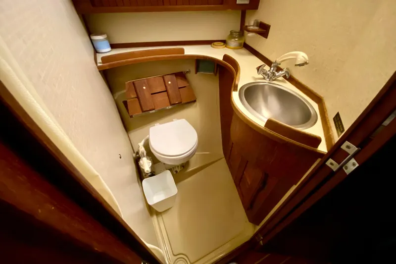 Slide: The Image of Compact bathroom in a 1992 Island Packet 29 sailboat, featuring a toilet and sink. - 74