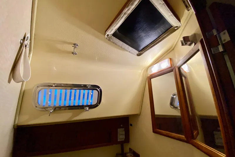Slide: The Image of Interior of 1992 Island Packet 29 sailboat bathroom with mirror and porthole. - 76