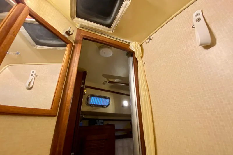 Slide: The Image of Interior of a 1992 Island Packet 29 sailboat, featuring a cabin with wooden accents. - 78