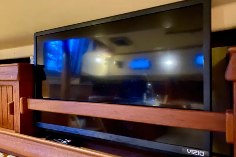 Slide: The Image of Flat-screen TV inside 1992 Island Packet 29 yacht cabin, with wooden interior accents. - 83