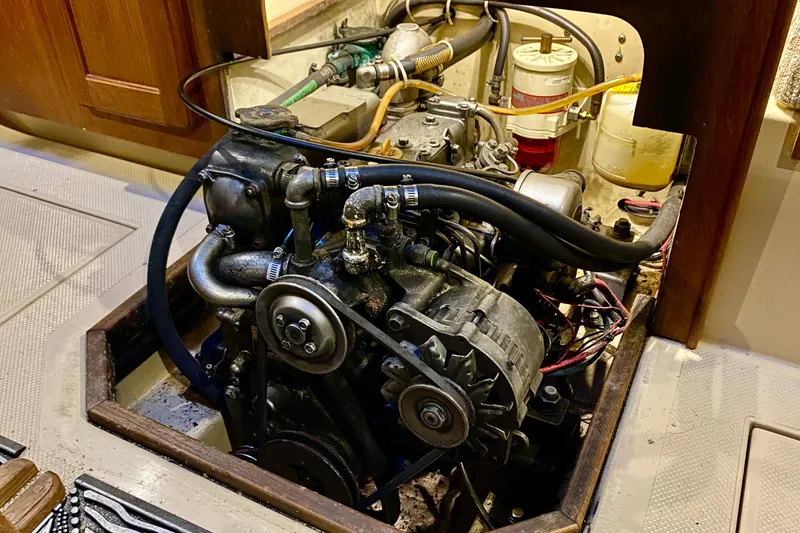 Slide: The Image of Engine compartment of a 1992 Island Packet 29 sailboat, showcasing mechanical components and wiring. - 88