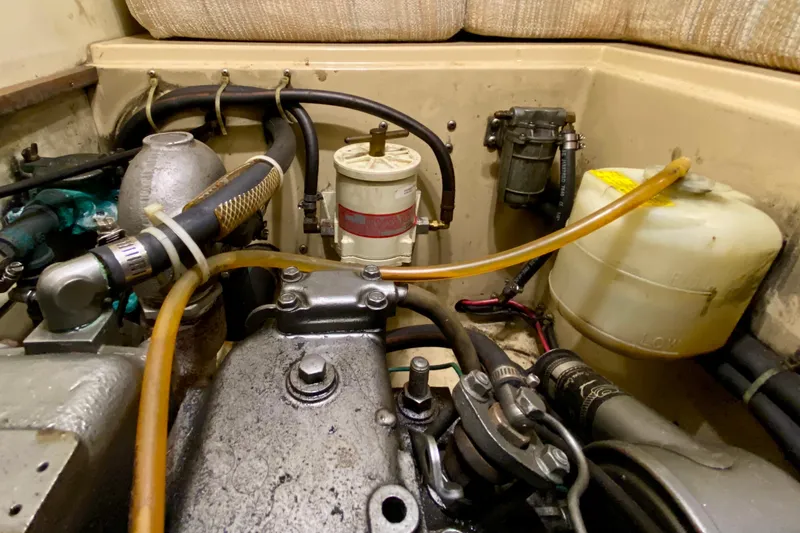 Slide: The Image of Engine compartment of a 1992 Island Packet 29 sailboat, showing hoses and components. - 90