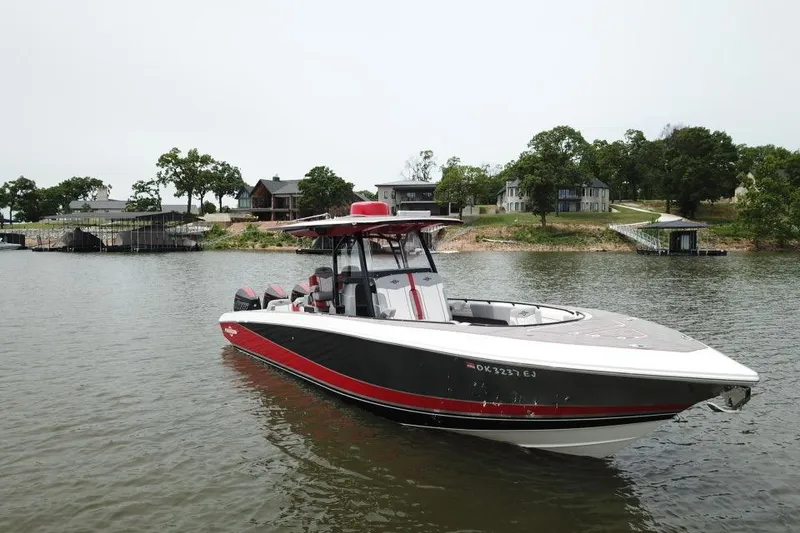 The Image of 2022 Fountain 34 SC boat on a lake near waterfront homes. - 0
