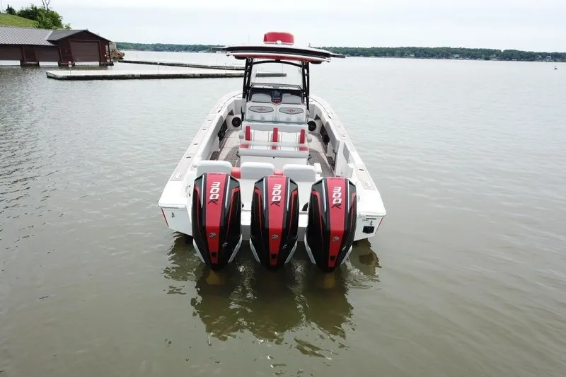 Slide: The Image of 2022 Fountain 34 SC boat with triple 300 horsepower engines on a calm lake. - 2