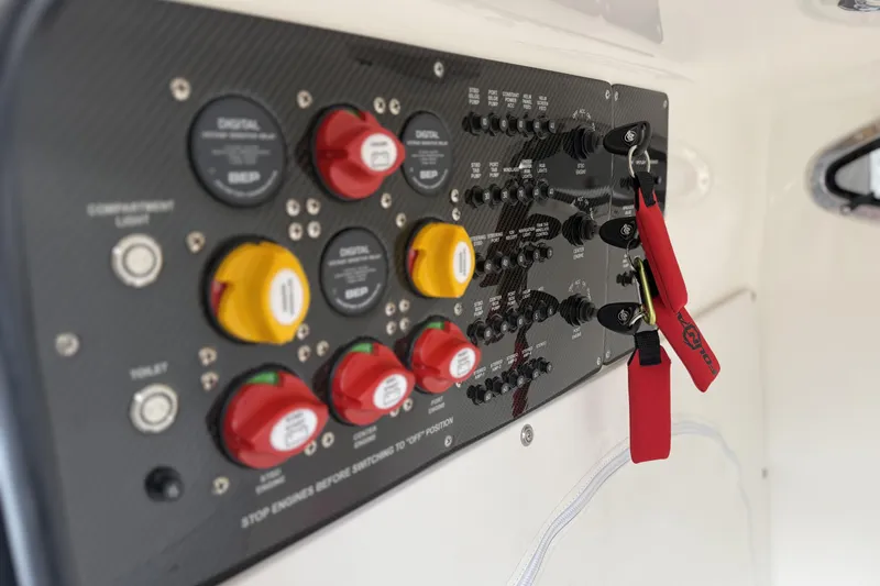 Slide: The Image of Control panel of 2022 Fountain 34 SC boat with switches and safety lanyards. - 24