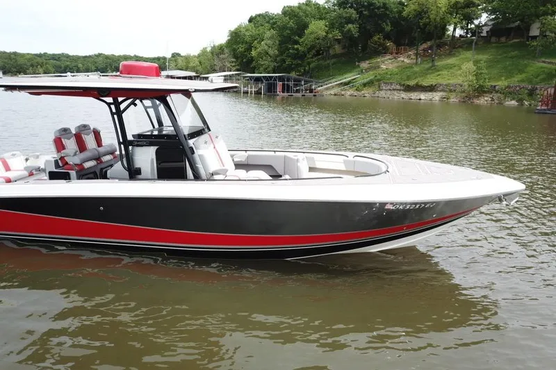 Slide: The Image of 2022 Fountain 34 SC boat with red and black accents on a lake. - 9