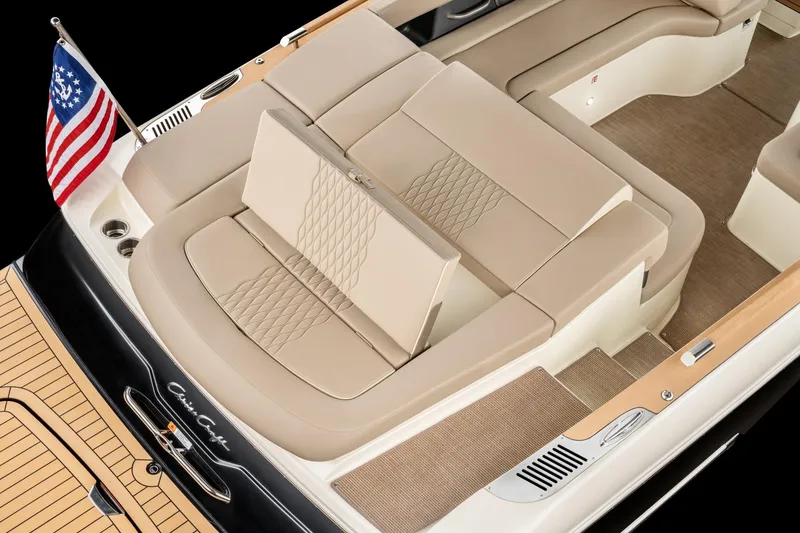 Slide: The Image of 2026 Chris-Craft Sportster 28 boat interior with beige seating and American flag. - 16