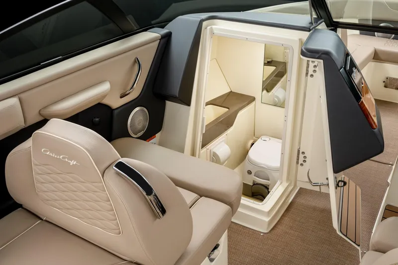 Slide: The Image of 2026 Chris-Craft Sportster 28 interior with luxurious seating and compact restroom. - 17