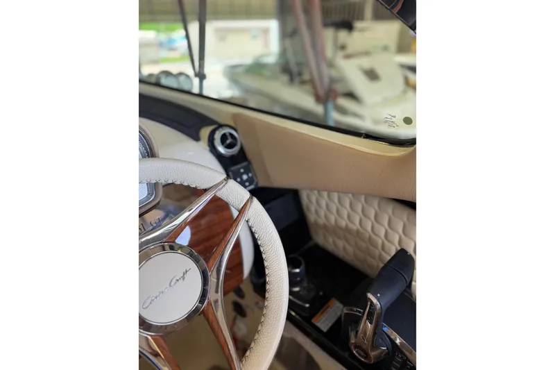 Slide: The Image of Interior view of 2026 Chris-Craft Launch 31 GT, featuring steering wheel and dashboard. - 12