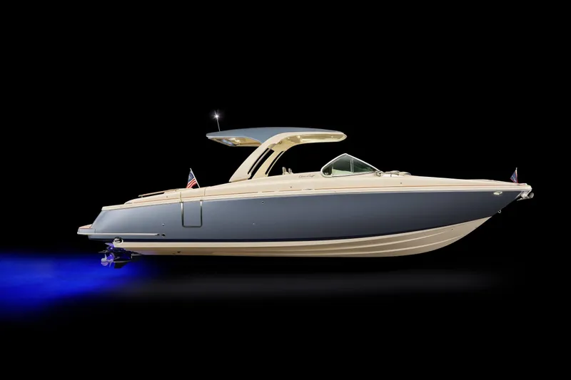 Slide: The Image of 2026 Chris-Craft Launch 31 GT boat with sleek design and blue hull, illuminated underwater. - 2