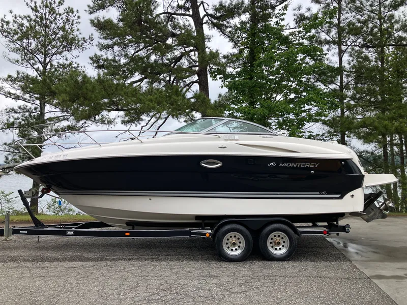 The Image of 2006 Monterey 250 SC boat on trailer, surrounded by trees. - 0