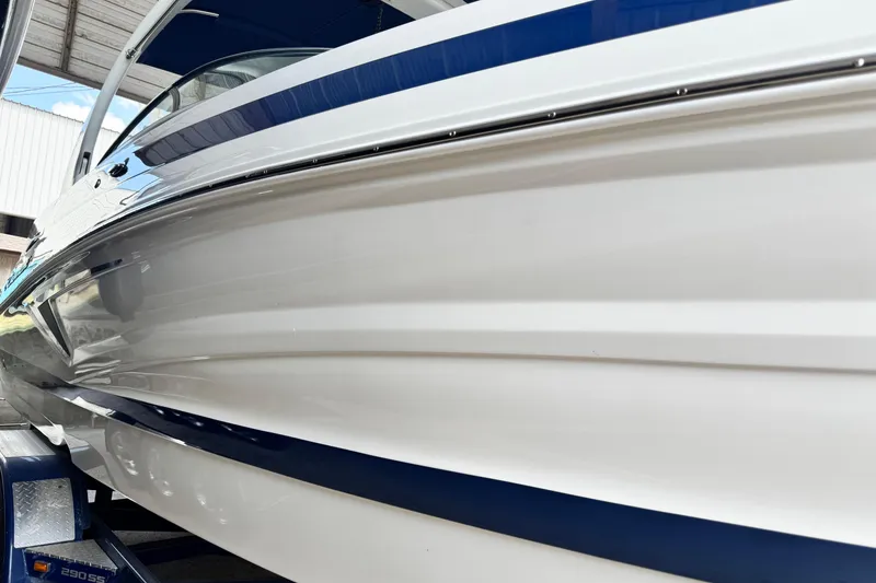 Slide: The Image of 2024 Crownline 290 SS boat side view, showcasing sleek design and blue accents. - 2