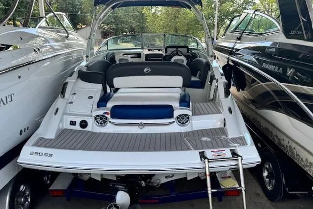 Slide: The Image of 2024 Crownline 290 SS boat with spacious deck and seating, docked between other boats. - 3