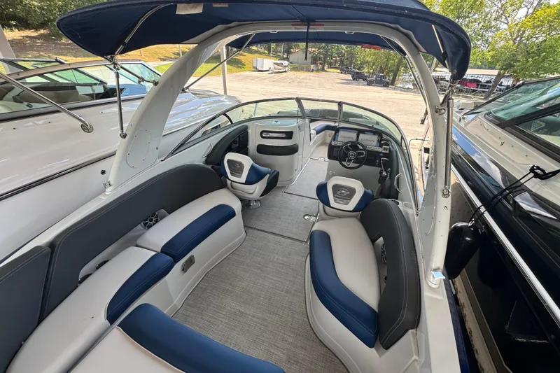 Slide: The Image of 2024 Crownline 290 SS boat interior with blue and gray seating, under a canopy. - 4