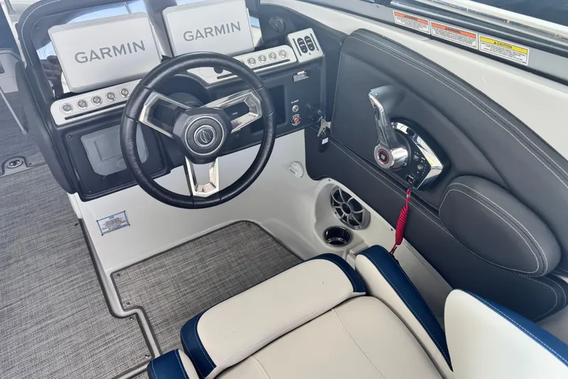 Slide: The Image of 2024 Crownline 290 SS boat cockpit with Garmin displays and steering wheel. - 7