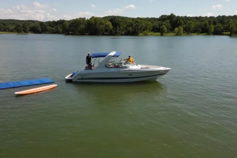 The Image of 2005 Formula 280 Bowrider on a serene lake with paddleboard and mat nearby. - 0