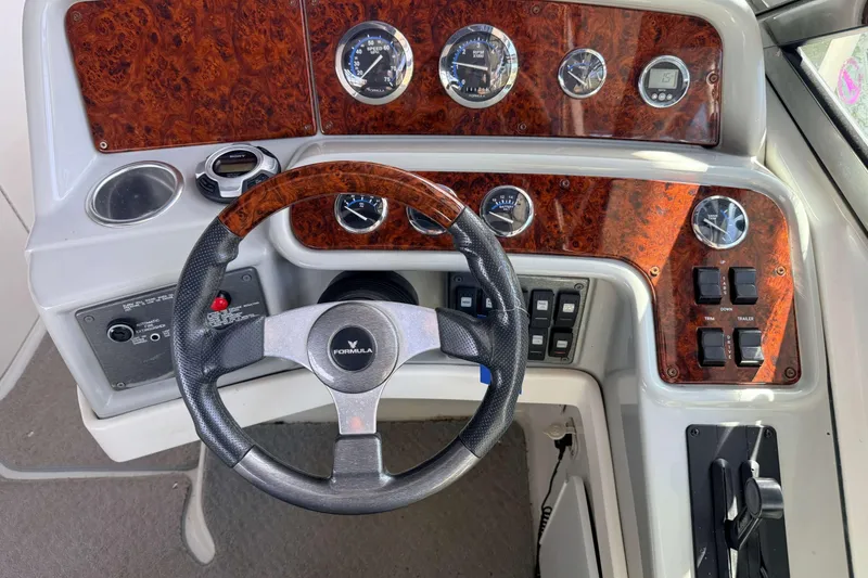 Slide: The Image of Steering wheel and dashboard of a 2005 Formula 280 Bowrider boat with wood accents. - 5
