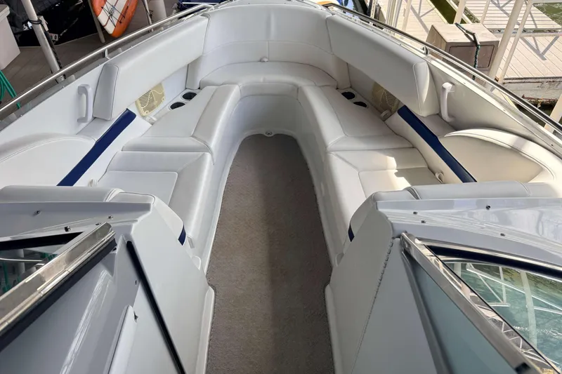 Slide: The Image of 2005 Formula 280 Bowrider interior with white seating and blue accents, docked at marina. - 6