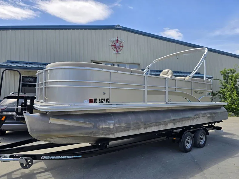 The Image of 2015 Sylvan Mirage 8522 pontoon boat on trailer outside warehouse. - 1