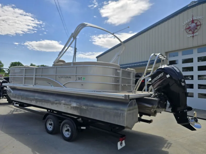 Slide: The Image of 2015 Sylvan Mirage 8522 pontoon boat on trailer outside warehouse. - 3
