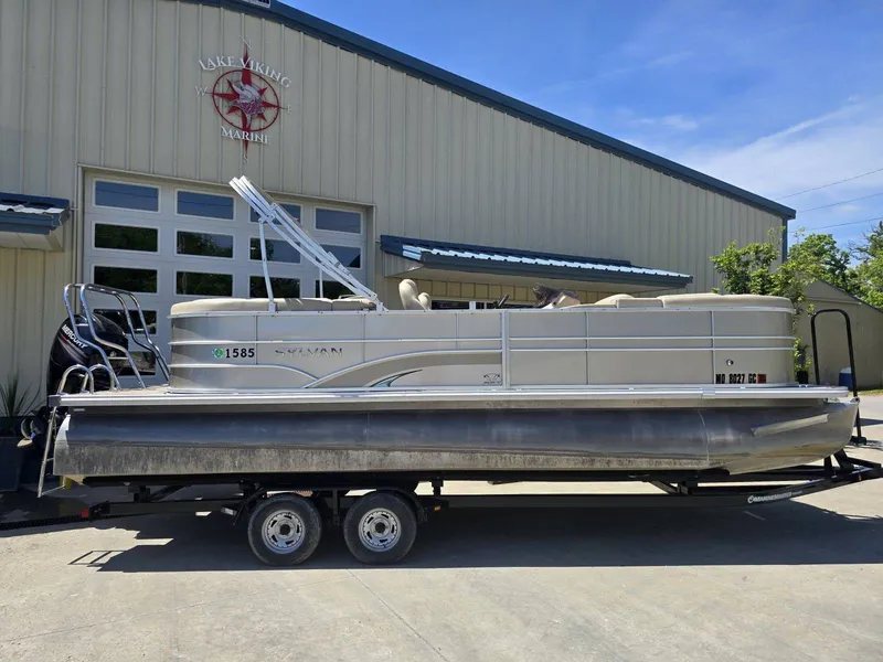 Slide: The Image of 2015 Sylvan Mirage 8522 pontoon boat on trailer outside marine building. - 6