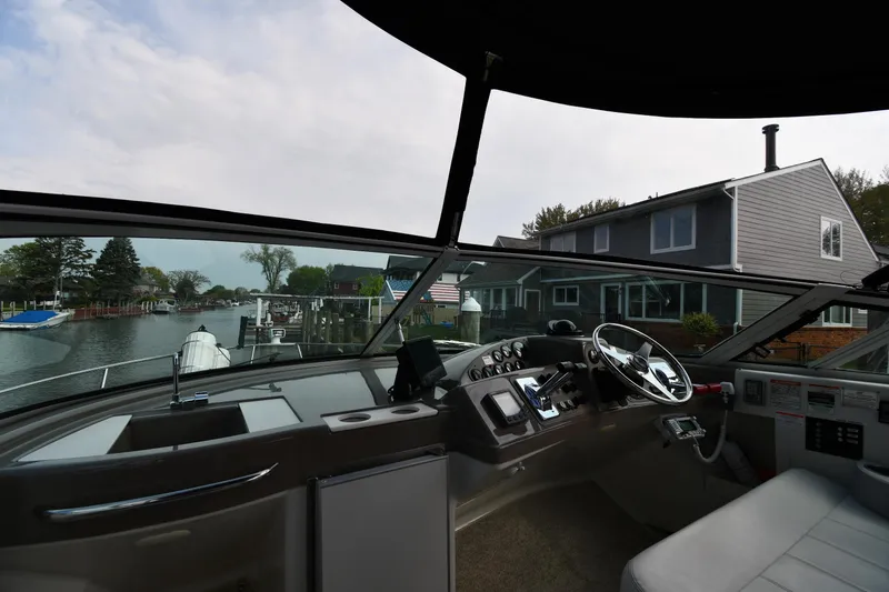 Slide: The Image of Interior view of a 2000 Carver 350 Mariner yacht, showcasing the helm and waterfront homes. - 12