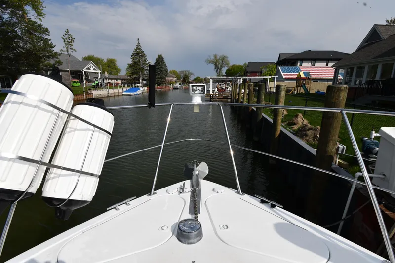 Slide: The Image of Bow view of 2000 Carver 350 Mariner navigating a narrow canal with waterfront homes. - 24