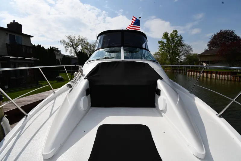 Slide: The Image of 2000 Carver 350 Mariner yacht with American flag, docked by a scenic canal. - 25