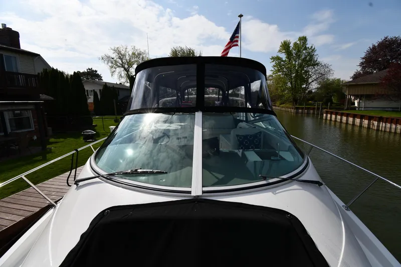 Slide: The Image of 2000 Carver 350 Mariner yacht docked by a canal, featuring sleek design and American flag. - 26