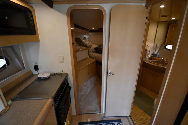 Slide: The Image of Interior of 2000 Carver 350 Mariner yacht, featuring kitchen, bedroom, and bathroom. - 27