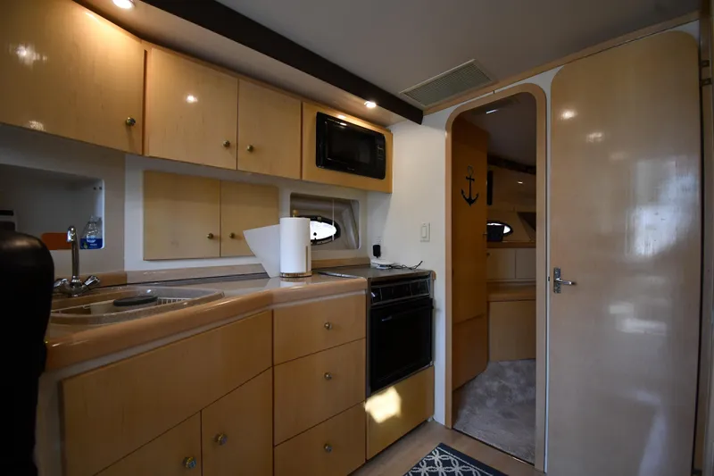 Slide: The Image of Interior of 2000 Carver 350 Mariner yacht featuring kitchen with wood cabinets and appliances. - 41