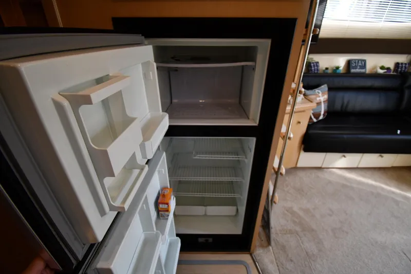 Slide: The Image of Interior of a 2000 Carver 350 Mariner showing an open refrigerator in the cabin. - 46