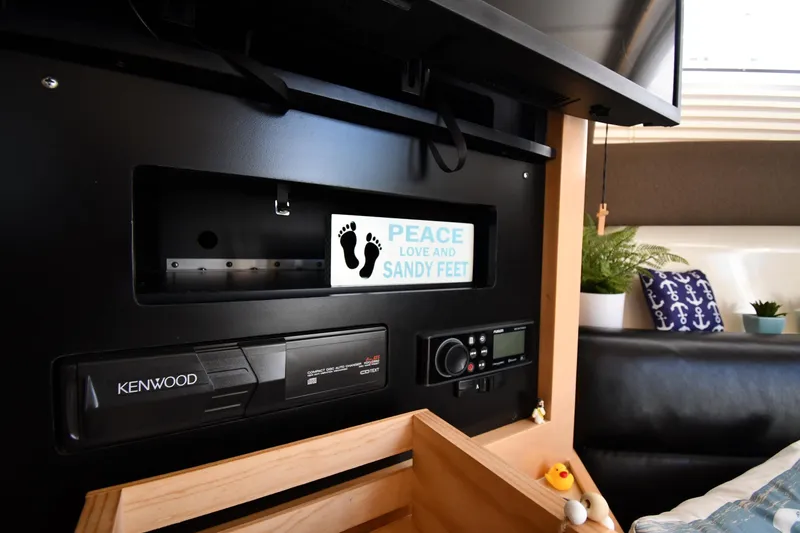 Slide: The Image of Interior of 2000 Carver 350 Mariner with Kenwood stereo and "Peace, Love, and Sandy Feet" sign. - 48