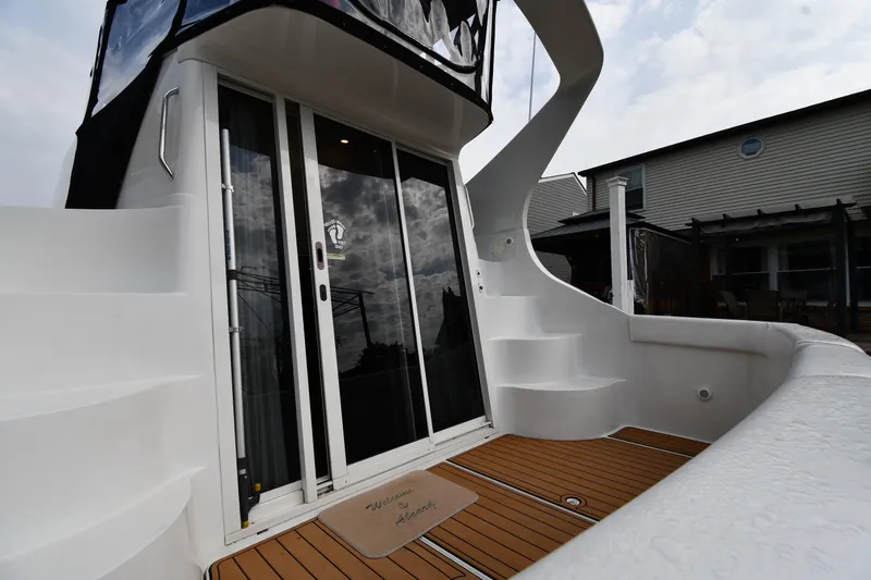 Slide: The Image of 2000 Carver 350 Mariner yacht with sleek white exterior and wooden deck. - 5