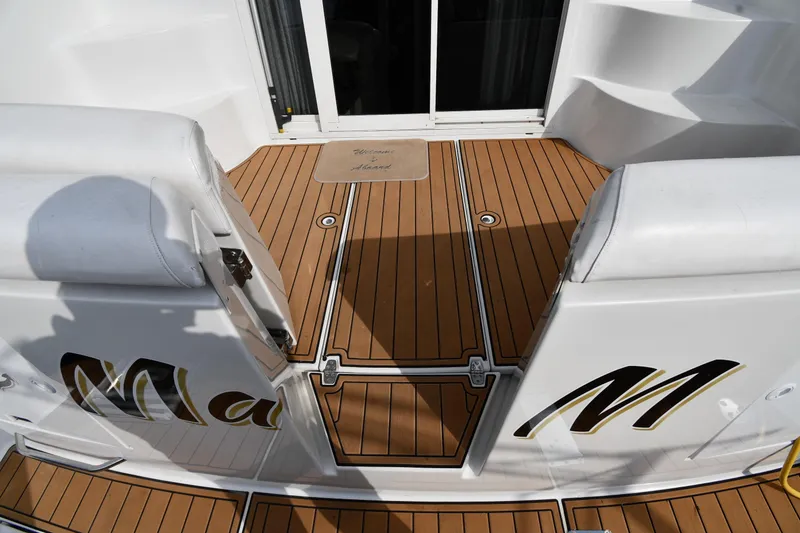 Slide: The Image of Carver 350 Mariner 2000 boat deck with teak flooring and cushioned seating. - 7