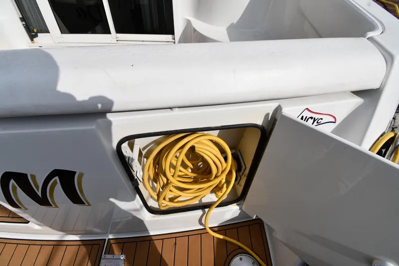 Slide: The Image of Storage compartment with yellow hose on 2000 Carver 350 Mariner boat deck. - 9