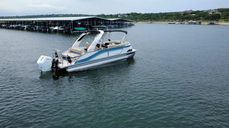 Slide: The Image of 2026 Harris Grand Mariner 230 on calm water near a marina. - 6
