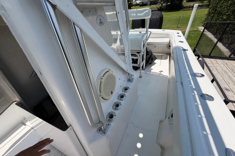 Slide: The Image of 2005 Competition 25 boat interior with seating and rod holders, docked near a grassy area. - 17