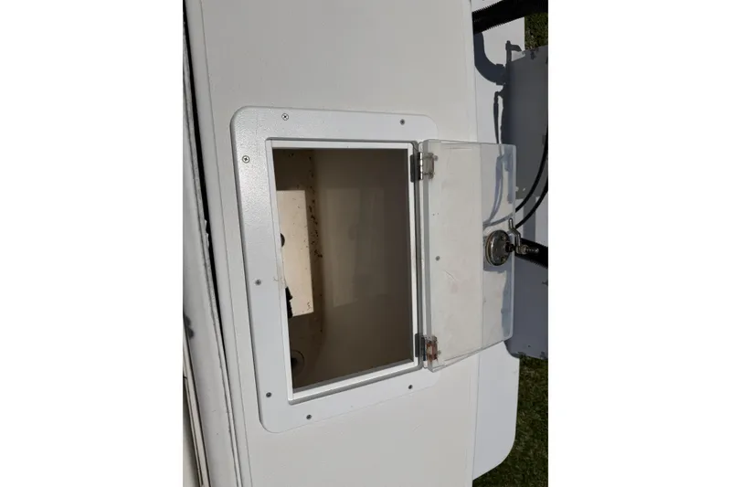 Slide: The Image of Open storage compartment on a 2005 Competition 25 boat, featuring a clear hinged door. - 19
