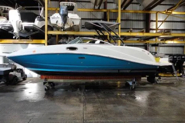 The Image of 2007 Sea Ray 260 Sundeck boat in storage, featuring a sleek blue and white design. - 1