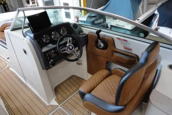 Slide: The Image of 2007 Sea Ray 260 Sundeck cockpit with brown leather seating and modern dashboard controls. - 10