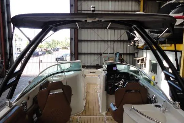 Slide: The Image of 2007 Sea Ray 260 Sundeck interior with seating and helm, docked in a covered area. - 7