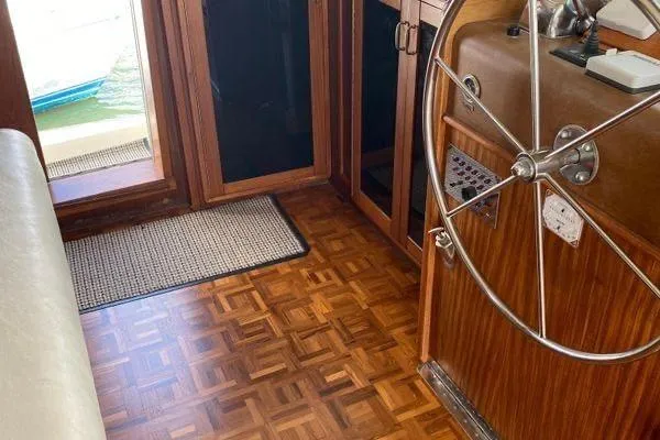 Slide: The Image of 1983 Hatteras 53 Motor Yacht helm with wooden flooring and classic steering wheel. - 22