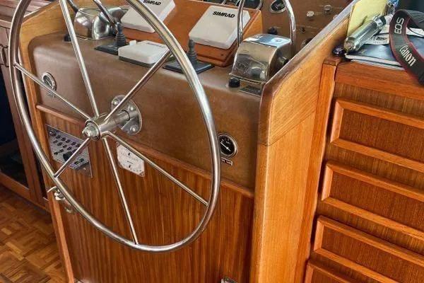 Slide: The Image of 1983 Hatteras 53 Motor Yacht helm with wooden finish and steering wheel. - 23