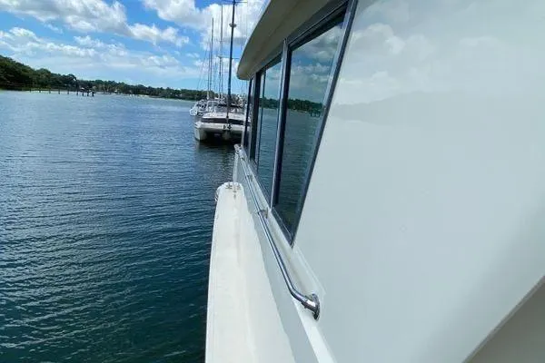 Slide: The Image of 1983 Hatteras 53 Extended Deckhouse Motor Yacht on serene water with blue sky. - 32