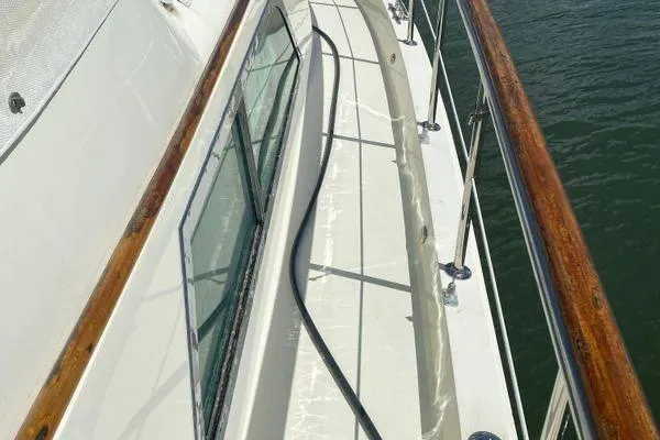 Slide: The Image of 1983 Hatteras 53 Extended Deckhouse Motor Yacht deck with wooden railings and windows. - 33