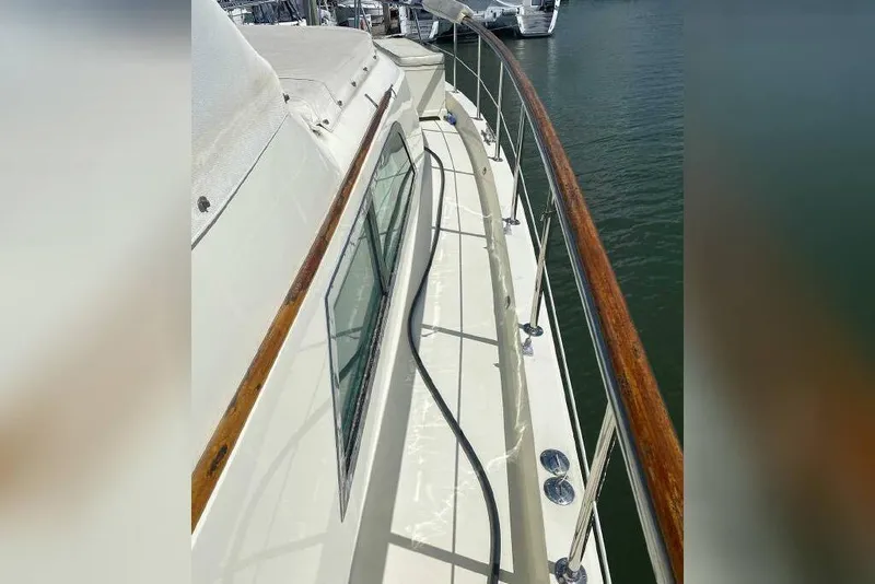 Slide: The Image of 1983 Hatteras 53 Extended Deckhouse Motor Yacht deck view with railing and windows. - 36