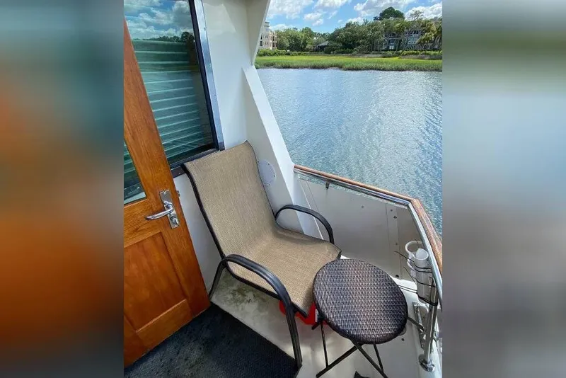 Slide: The Image of Outdoor seating area on 1983 Hatteras 53 Extended Deckhouse Motor Yacht, overlooking serene waterway. - 39