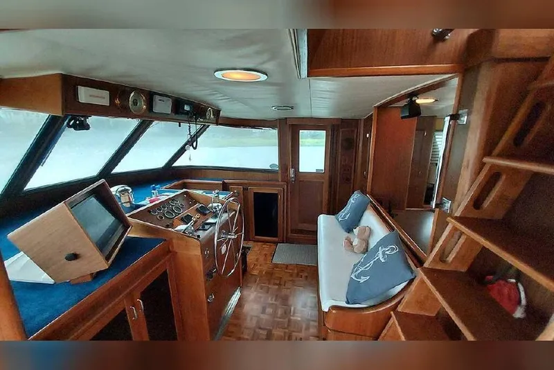 Slide: The Image of Interior of 1983 Hatteras 53 Extended Deckhouse Motor Yacht, featuring helm and seating area. - 42